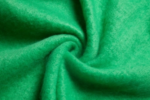 Close-up of bright green textured fleece fabric showing thick and soft polyester fibers