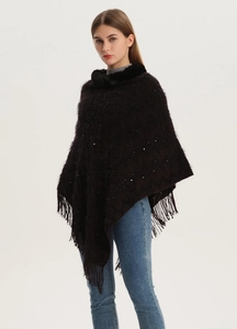 Close-up of sequined knit poncho with faux fur collar and fringe tassels in dark coffee