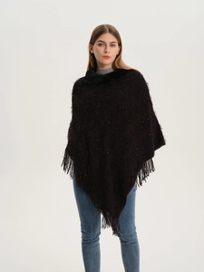Detail of dark brown knit poncho featuring faux fur collar and fringed sequin hem