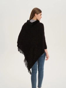 Detail of dark brown knit poncho featuring shimmery sequins, fringe edges and a fur collar