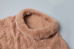 Close-up of caramel knit poncho collar with sequins and plush faux fur trim