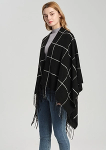 Detail view of monochrome plaid shawl with elegant black fringe trim and soft knit texture