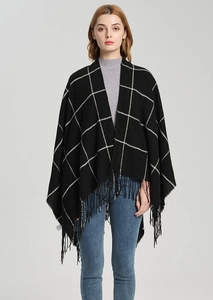 Detail of black and white plaid shawl with long tassels and soft knit texture