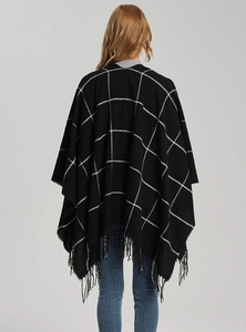 Back view of a classic black and white plaid poncho featuring fine tassel trim details