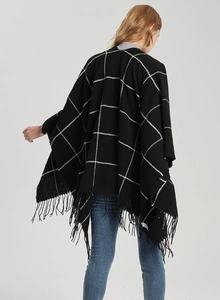 Rear view of a black and white plaid shawl featuring classic fringe hem and a wide fit