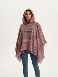 Detail eines rot-schwarzen Kapuzenponchos mit weicher Strickstruktur und Fransen am Saum