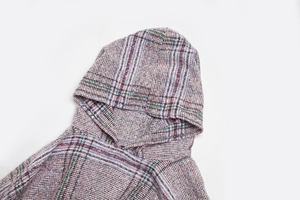 Detailansicht des mehrfarbig karierten Tweed-Stricks an einem Kapuzen-Poncho-Cape