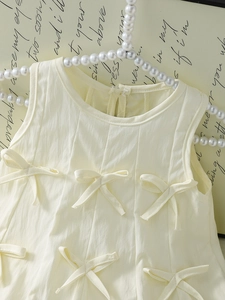Sleeveless cream yellow girls dress with bow details and textured cotton fabric