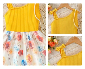 Detail of yellow ribbed knit shoulder with bow and vibrant floral tulle skirt