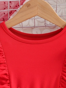 Gros plan sur l'encolure de la robe rouge pour fille avec volants et coutures fines