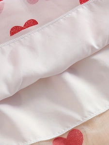 Détail de broderie cœur rouge sur maille blanche avec doublure en satin lisse
