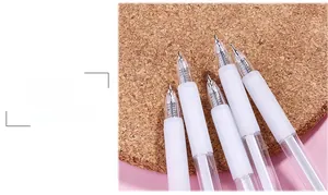 Close-up of transparent gel pens with white soft rubber grips on a cork base