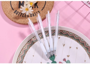 Detail of four transparent retractable gel pens with white soft grips on a pink background