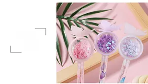 Détail de stylos papillon créatifs avec des paillettes en forme de cœur dans le capuchon