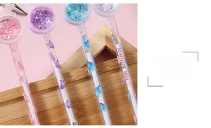 Gros plan sur des stylos à paillettes avec cœurs et imprimés papillon colorés