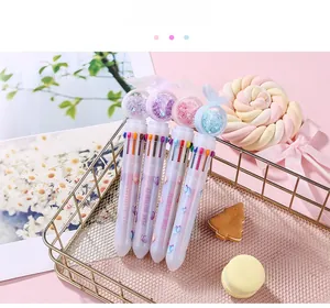 Close-up of 10-color ballpoint pens with pink butterfly sequins in a gold basket