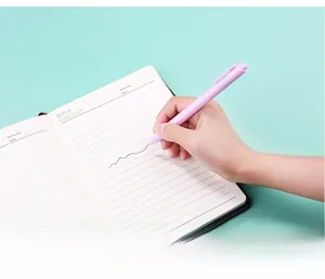 Detail of lavender retractable gel pen writing smoothly on a paper notebook