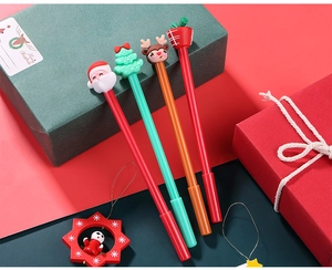 Close-up of Christmas gel pen set with Santa and reindeer cartoon toppers on gift boxes