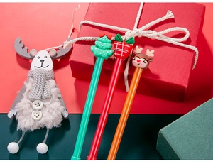 Close-up of Christmas gel pens with Santa tree and reindeer silicone toppers in a gift box