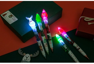Detail of LED glowing Christmas ballpoint pens with Santa and tree toppers