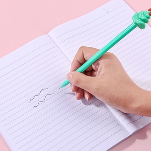 Creative Christmas gel pen with green cactus topper writing on a white notebook