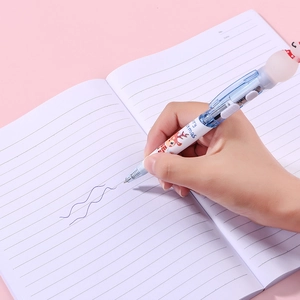 Hand writing with a multicolor Christmas ballpoint pen featuring a snowman topper