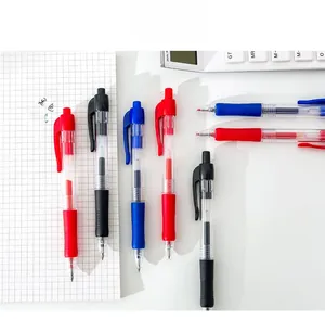 Close-up of retractable gel pens with non-slip grips on a white grid notebook background