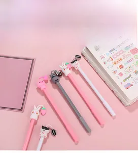 Detail of cute animal gel pens with silicone cartoon rabbit and pig charms on a pink desk