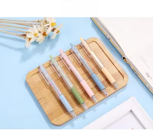 Detail of 5 retractable Morandi gel pens with pastel grips in a wooden tray