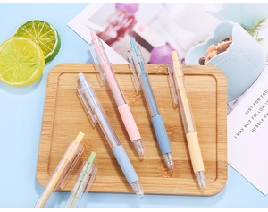 Detailed macro view of 0.5mm macaron gel pens with soft rubber grips on a wooden tray