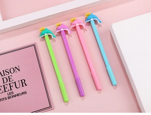 Détail de quatre stylos colorés avec des dauphins mignons et couronnes jaunes sur fond rose