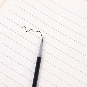 0.5mm black gel pen refills with metal tip shown writing smoothly on lined paper