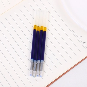 Close-up of four transparent blue ink refills with metal tips on lined paper