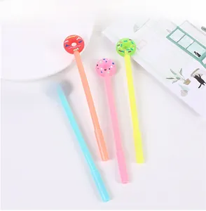 Gros plan de quatre stylos gel donut colorés en bleu, orange, rose et vert