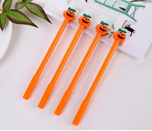 Nahaufnahme von vier orangefarbenen Halloween-Kürbisstiften mit 3D-Smiley-Aufsatz am Schreibtisch