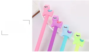 Close-up of cute 3D alpaca silicone toppers on colorful gel pens in a desk setting