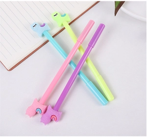 Close-up of four cute llama toppers on colorful gel pens with a notebook on a desk