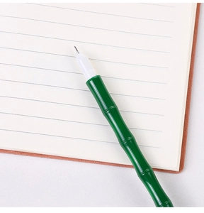 Macro detail of creative green bamboo-shaped gel pen on a lined notebook page