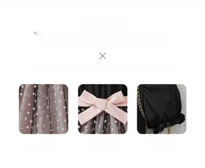 Detail of pink satin bow and black heart-patterned mesh on a girl's stylish dress