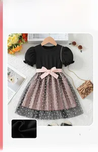 Detail of girls' black cotton dress with pink satin bow and heart patterned tulle skirt