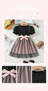 Detail of girls' summer dress featuring mesh lace embroidery and pink satin bow accent