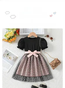 Detail of girls' dress featuring a pink bow and black mesh skirt with heart patterns