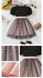 Detail of girls' layered mesh dress with heart patterns and pink waist belt accent