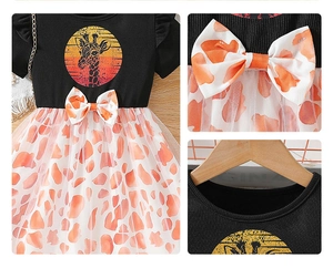 Detail of girls dress featuring giraffe print tulle skirt and a decorative waist bow