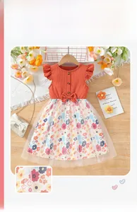 Detail of girls' orange ruffled bodice with a decorative waist bow and mesh floral skirt