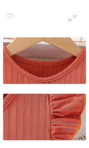 Detail of ribbed knit fabric on girl's brick red princess dress with flutter sleeves