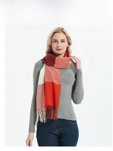 Close-up of multicolor plaid scarf with red and orange blocks and soft fringe detail
