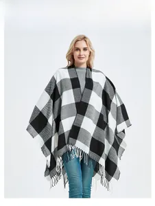 Close-up of black and white checkered knit shawl with stylish fringe hem detail