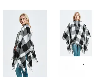 Detail of buffalo check knit poncho with elegant long fringe tassels for autumn