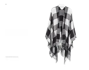 Detail of DUSTY OASIS black and white checkered poncho with long tassel hem and soft knit texture